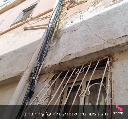 צנרת חיצונית על קיר בניין עם חלון